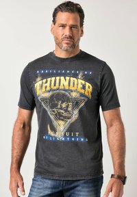 Grå grafisk t-shirt med gul "THUNDER"-tekst, kraniedesign og trekantmønster. Kortærmet og med rund hals.