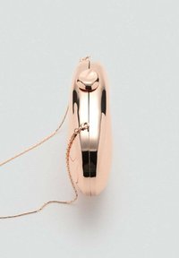 Clutch compacto en oro rosa con una superficie metálica suave, forma redondeada y una delicada cadena para llevar. Cuenta con un cierre en la parte superior.