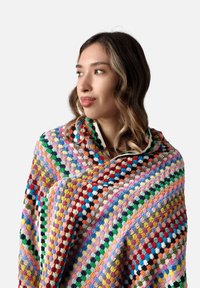 Multicolored crochet blanket with a textured pattern, featuring vibrant hues of red, blue, green, pink, and orange in a hexagonal motif.