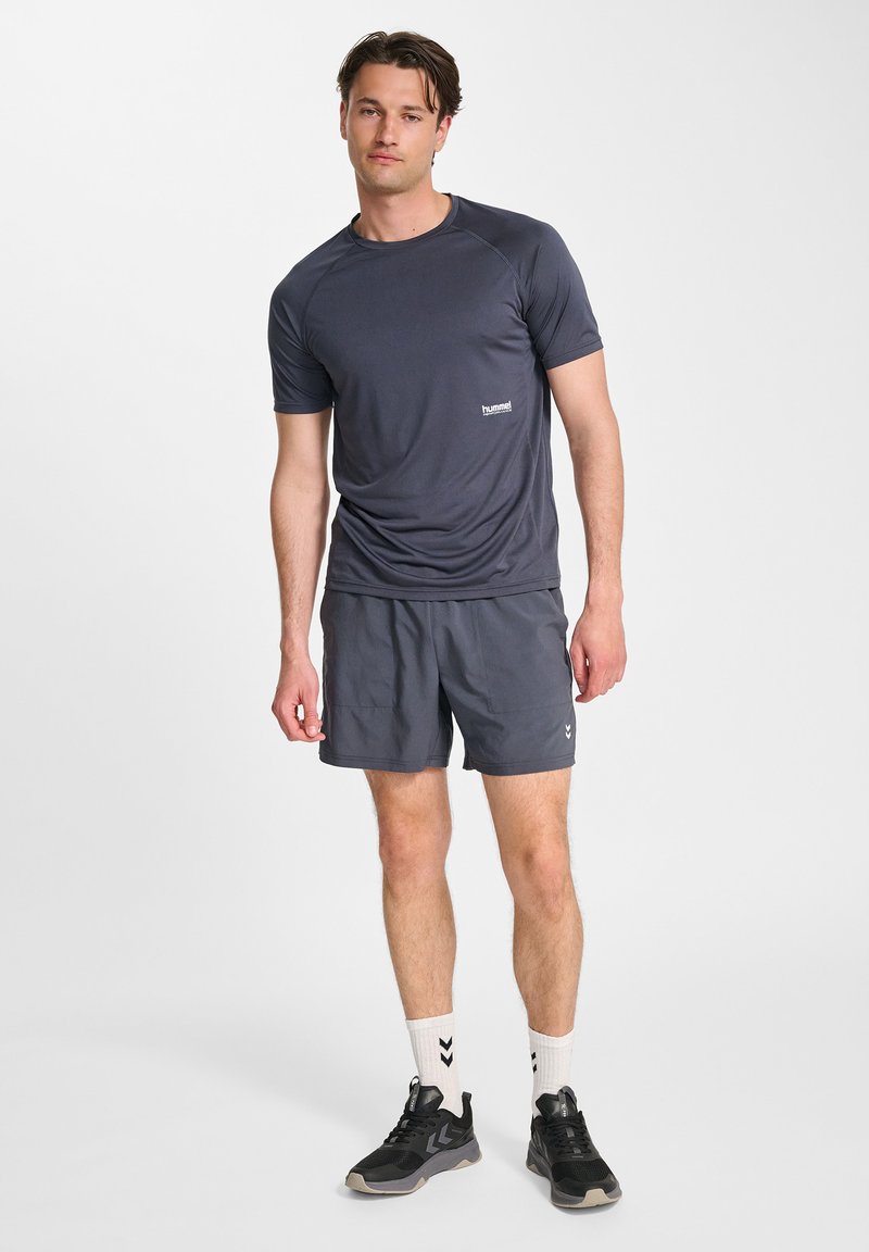 Męski strój sportowy składający się z ciemnoszarej koszulki z krótkim rękawem i dopasowanych szortów. Materiał wydaje się lekki o gładkiej teksturze.
