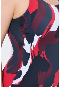Yhdistelemä puvun vesipuku joustavasta kankaasta, jossa on monivärinen abstrakti printti punaisena, laivastonsinisenä ja valkoisena, sivuilla rypytetty yksityiskohta.