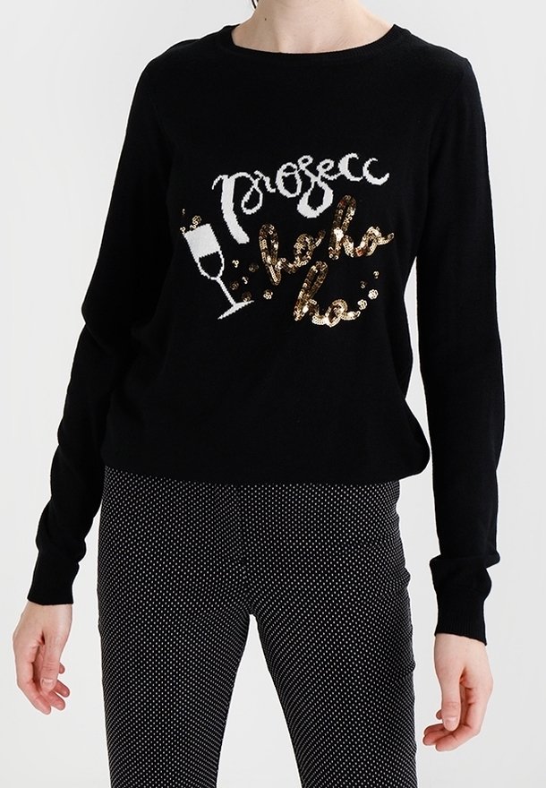 Černý svetr s dlouhým rukávem s nápisem "Prosecco hello ho" a motivem skleničky na šampaňské, spojený s černobílými puntíkovanými kalhotami.