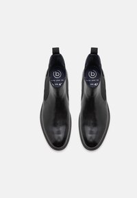 Botas de tobillo de cuero negro con un acabado suave, paneles laterales elásticos y puntera redonda. Talla 42 indicada en la plantilla.
