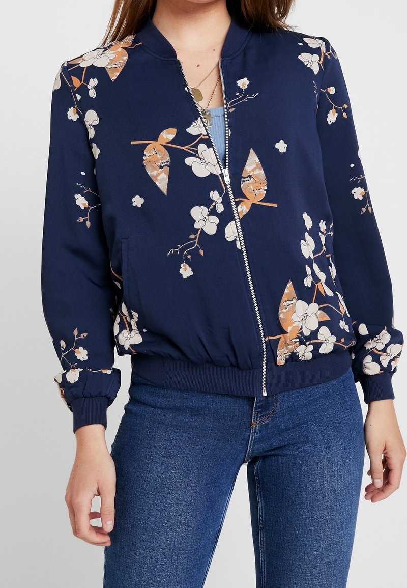 Námořnická bomber bunda s květinovým potiskem, se zipem vpředu, žebrovanými manžetami a pasem, vyrobená z hladké tkaniny s lehkou strukturou.