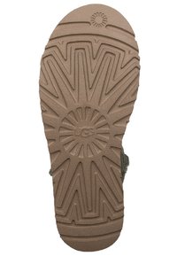 Bruine rubberen sandaalzool met een getextureerd zigzagpatroon en een centraal cirkelvormig ontwerp, met het geperste logo "UGG."