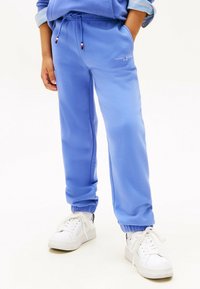 Lysblå sweatpants lavet af fleece materiale, med elastisk talje med snor og ribstrikkede manchetter. Logo på venstre lår.