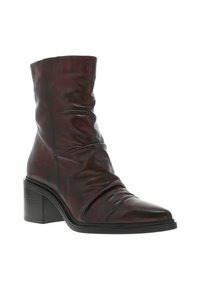 Botte de cheville en cuir marron avec un design drapé, bout pointu et un talon épais. Présente des plis subtils et un extérieur texturé.