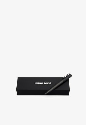 Schwarzer Hugo Boss Stift mit strukturiertem Schaft, neben einer rechteckigen schwarzen Box mit weißer Markenbeschriftung platziert.
