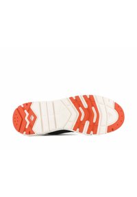 Semelle de chaussure de sport noire avec des accents blancs et orange. Présente une surface texturée avec plusieurs motifs de traction pour une adhérence et une stabilité accrues.