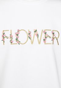 Vit bomulls t-shirt med ordet "FLOWER" broderat i guld, pryds med rosa blommiga accenter och gröna blad.