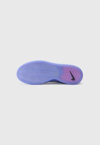 Nike schoen outsole met een verloop van paars naar roze, met een textuurpatroon en een kenmerkend zwart logo aan de zijkant.