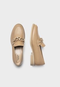 Beige Lederloafers mit goldener Kettenakzent, abgerundetem Zeh und niedrigem, gestapeltem Absatz mit strukturiertem Gummisohle.