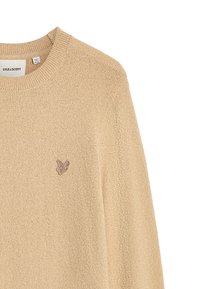Maglione beige lavorato a maglia con colletto rotondo, tessuto testurizzato e un piccolo logo marrone sul lato sinistro del petto. Design casual con maniche lunghe.