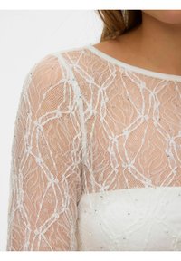 Bela obleka s prosojnimi čipkastimi dolgimi rokavi, okrašena z nežnim cvetličnim vzorcem in razpršenimi srebrnimi okraski; gladko, enobarvno krilo.