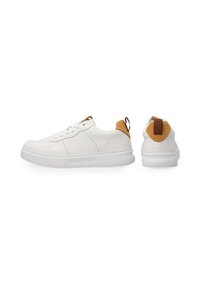Weiße Sneakers mit einem glatten Leder-Obermaterial, durchbrochenen Details, rundem Zehenbereich und braunem Fersenanhänger. Mit flachen Schnürsenkeln und einer dicken Sohle.