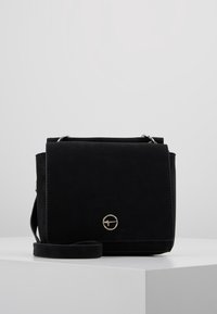 Borsa a tracolla nera con una texture liscia, dettagli in metallo argento e un logo frontale arrotondato. Presenta una chiusura a patta e una tracolla regolabile.