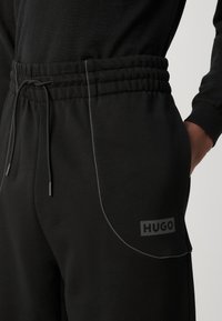 HUGO NIPIPEPANT - Tracksuit bottoms - black