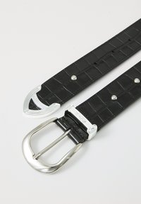 Curea din piele neagră cu textură de crocodil, având o cataramă rectangulară cu nuanță argintie și studuri decorative argintii suplimentare pe curea.