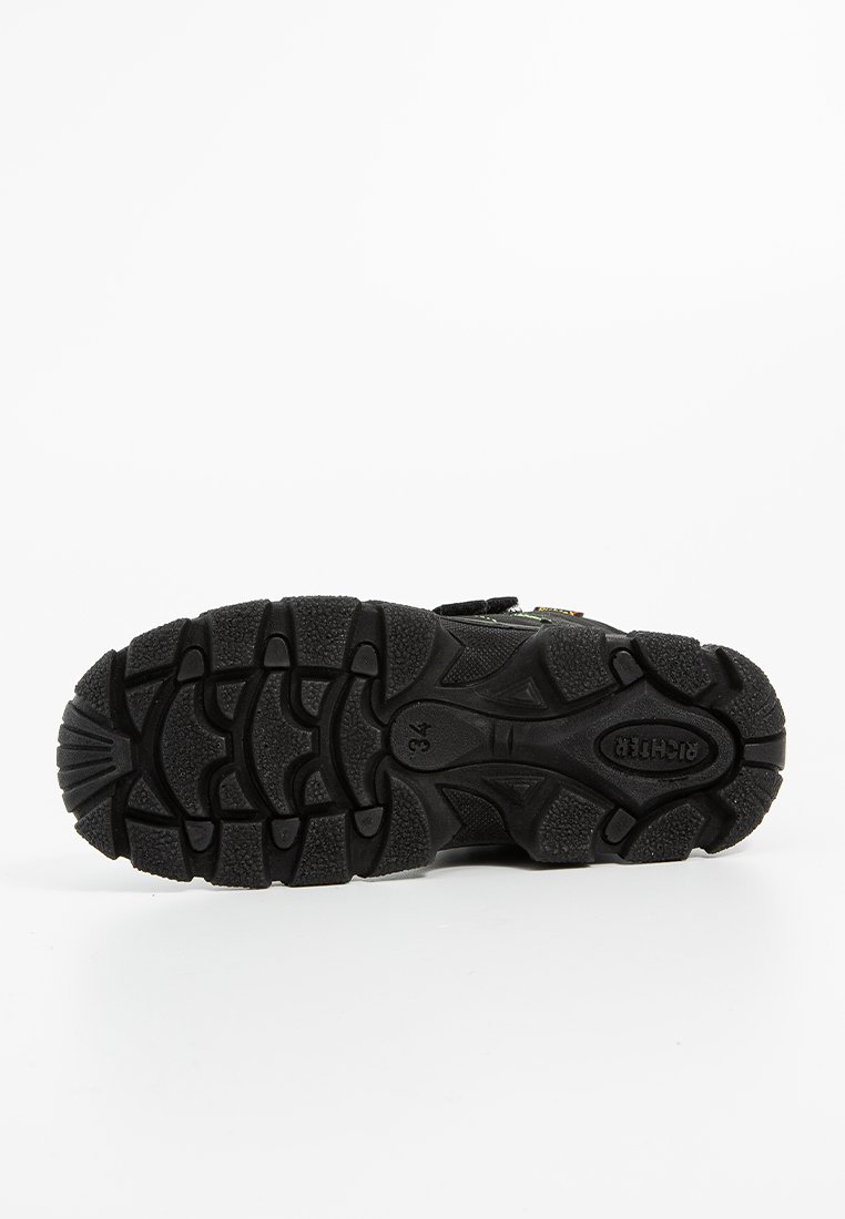 Schwarze Wanderschuhsohle mit tiefem Profil für Griffigkeit, Gummi-Material, strukturiertem Oberflächen und detaillierten Mustern für Halt.