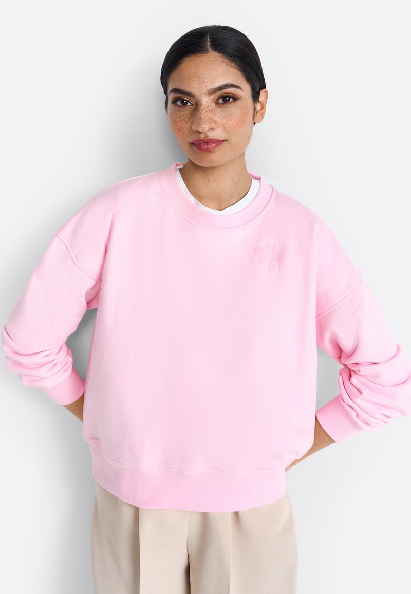 Felpa rosa con scollatura rotonda, spalle cadute e polsini a costine. Presenta un delicato motivo floreale sul petto. Materiale morbido.