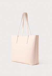 Hellrosa glatte Ledertasche mit zwei Schulterriemen, die auf einem weißen Hintergrund aufrecht steht.