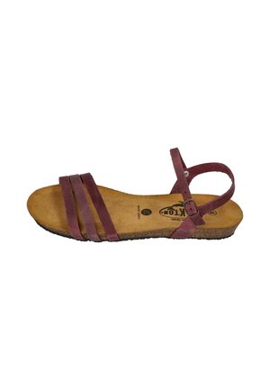 Brown leather flat sandal with three front straps, ankle strap with buckle, cork sole, and soft footbed, viewed from the side.