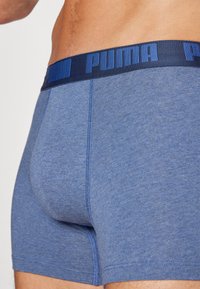 Boxeri albaștri Puma, cu un brâu de culoare bleumarin cu branding "PUMA". Textură moale, cu cusături fără sudură și o potrivire strânsă.