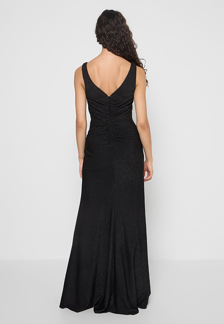 Czarna wieczorowa sukienka z dopasowaną górą i rozkloszowanym dołem. Posiada dekolt w kształcie litery V oraz marszczenia na plecach, wykonana z błyszczącego materiału.