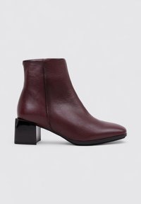 Bottine en cuir bordeaux avec un bout pointu, finition mate et un grand talon noir épais. Design élégant adapté à diverses occasions.