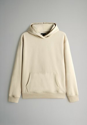 Lichtbeige katoenen hoodie met een voorzak in kangoeroestijl, lange mouwen en een capuchon met trekkoord. Soepele textuur en geribbelde details aan de onderkant.