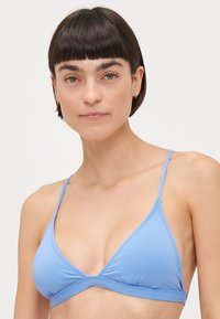 Svetlo modrý trojuholníkový bikiny top s tenkými nastaviteľnými ramienkami a pásom pod prsiami. Hladká textura a minimalistický dizajn.