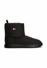 Zwarte geïsoleerde enkelschoen met een gladde, matte afwerking, voorzien van een merkpatch en een rubberen zool met rechthoekige noppen voor grip.