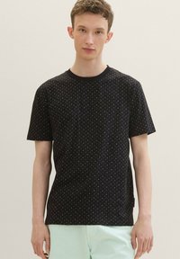 Black short-sleeve t-shirt featuring a subtle geometric pattern, made of soft fabric with a round neckline and relaxed fit.