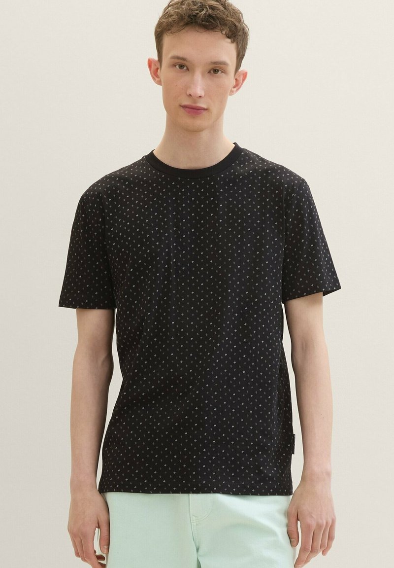 Black short-sleeve t-shirt featuring a subtle geometric pattern, made of soft fabric with a round neckline and relaxed fit.