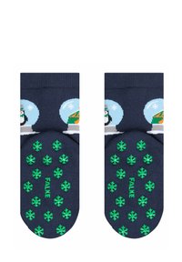 Marineblaue Socken mit Schneekugelmotiven, die einen Pinguin und eine festliche Szene zeigen. Die Unterseite hat grüne Gummischneestern-Griffe und ist mit "FALKE" gebrandet.