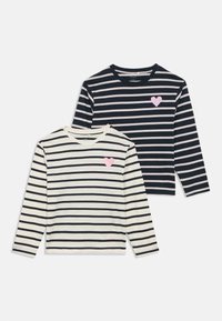 Dve majici z dolgimi rokavi: ena kremne barve z mornarsko modrimi črtami in roza srčnim našitkom, druga mornarsko modra s svetlimi črtami in podobnim srčnim našitkom.