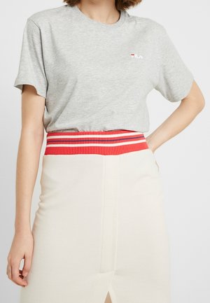 Szara bawełniana koszulka z krótkim rękawem, z małym czerwono-białym logo. Połączona z kremową spódnicą, podkreśloną paskiem w czerwone paski.