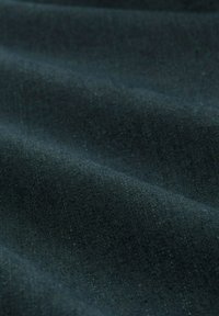 Tejido oscuro con una superficie texturizada, que presenta un suave y sutil brillo. El material tiene un aspecto liso y ligeramente arrugado, mostrando tonos profundos.