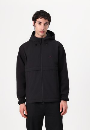 Zwarte hoodiejack met een ritssluiting aan de voorkant, featuring een horizontale paneel, verstelbare trekkoorden en een klein logo op de borst. Zachte textuur.