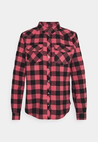 Red and black plaid flannel shirt with a button-up design, long sleeves, two chest pockets, and metal buttons. Soft fabric texture.