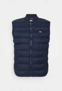 Chaleco sin mangas acolchado en azul marino con cremallera frontal y pequeño logo rectangular en el pecho izquierdo sobre fondo blanco.