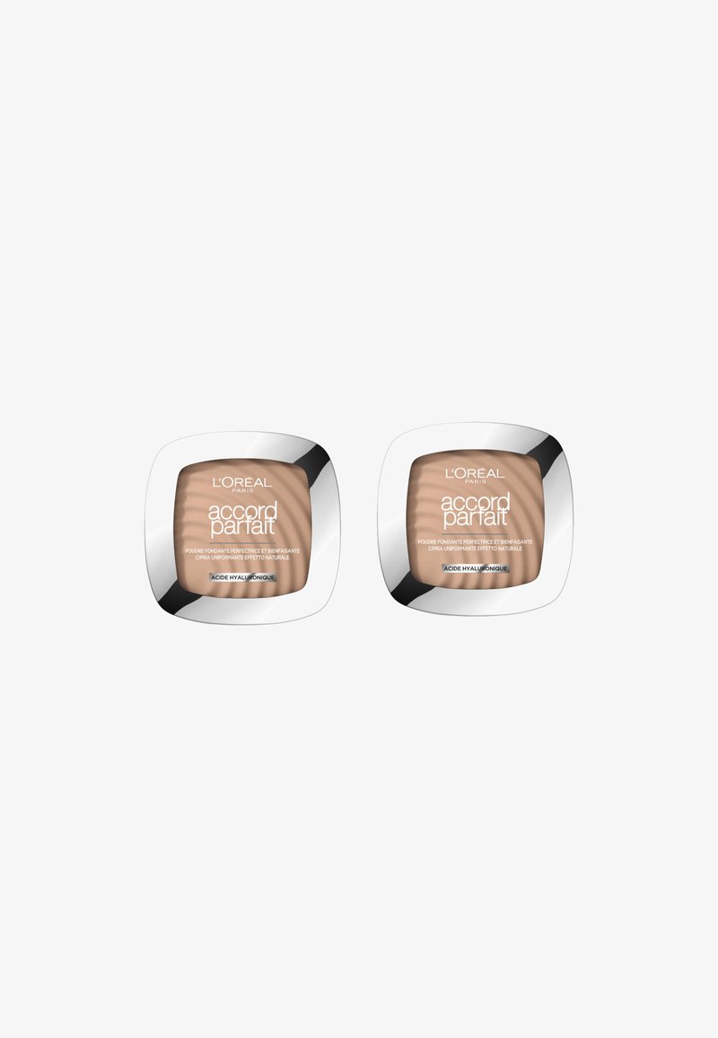 Deux compacts de poudre L'Oréal Accord Parfait avec des boîtiers carrés en métal argenté réfléchissant, contenant de la poudre beige à l'intérieur et étiquetés en plusieurs langues.
