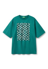 Tyrkysové bavlněné tričko s boxy střihem, s černobílým vzorem listů uprostřed. Krátké rukávy a kulatý výstřih.