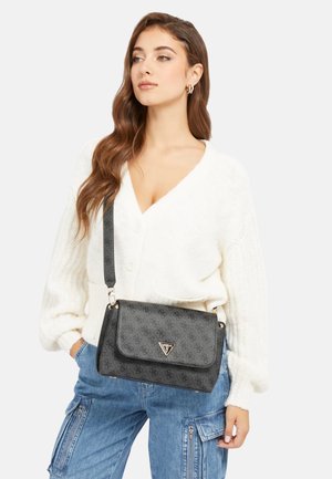 Sac noir à monogramme avec rabat, matériel en argent, présentant un motif texturé et une sangle ajustable.