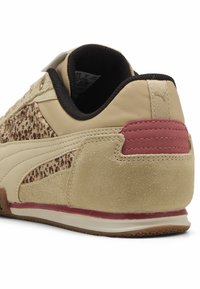 Bež patike s teksturiranim panelom u dezenu leopard, akcentima od nubuka i glatke kože, te maroon petnim kapicom. Gumeni potplat s reljefnim detaljima.