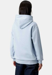 Sudadera con capucha de color azul claro y corte relajado, con una gran capucha y puños y dobladillo de canalé. Textura de tela suave, sin patrones.