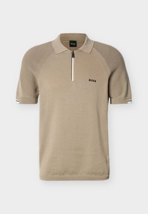 Beigenvärinen lyhythihainen poolopaita, jossa on resorit olkapäissä, neljännesvetoketju edessä ja "BOSS"-logo vasemmassa rinnassa.