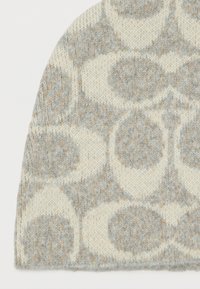 Beanie lavorato a maglia con una texture morbida e calda; motivi circolari in grigio chiaro e crema con accenti beige sottili. Design con parte superiore arrotondata.