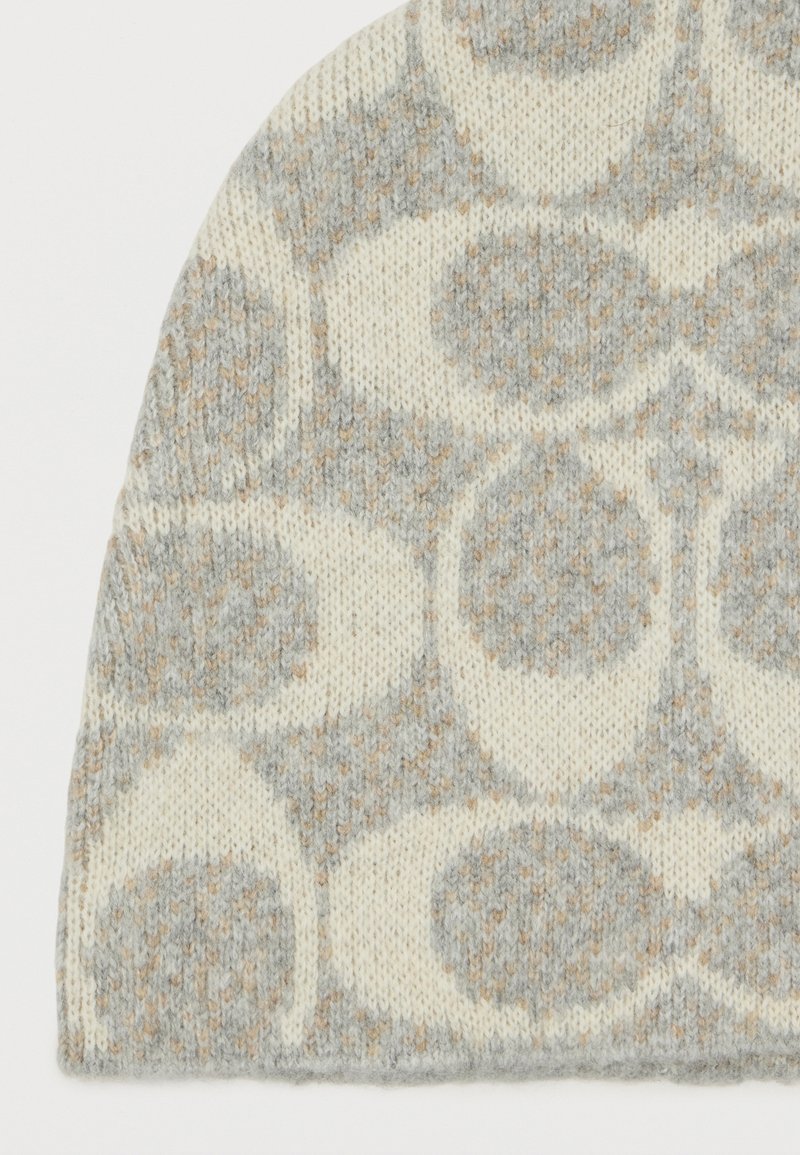 Knit beanie featuring a soft, warm texture; circular patterns in light gray and cream with subtle beige accents. Rounded top design.
