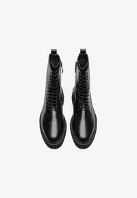 Botine negre din piele, cu un finisaj neted, având un sistem de prindere cu șireturi în față și un fermoar pe lateral, precum și o talpă din cauciuc texturată.